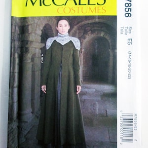 May include: McCall's Costumes pattern M7856. The pattern features a woman in a long, olive green coat with a high collar and lace detailing. The pattern size is E5, fitting sizes 14-22. The background shows a stone archway.