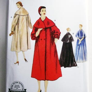 May include: Vogue Patterns V1977 sewing pattern envelope featuring illustrations of a double-breasted coat with a large collar in red and beige, and a cape with a dress in black and blue. Text includes V1977, VOGUE PATTERNS, and 1955 design.