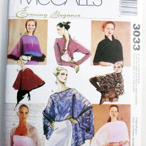 May include: A McCall's Evening Elegance sewing pattern envelope, number 3033, featuring illustrations of various capes, boleros, and wraps. The designs include a purple ombre cape with fur trim, a mauve ruffled bolero, a black cape, and a blue patterned wrap.