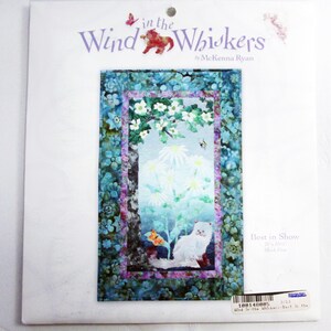 May include: A craft kit titled "In the Wind Whiskers" by McKenna Ryan. The image features a white cat in a garden scene with daisies, butterflies, and a bee. The kit is framed by a blue floral border.