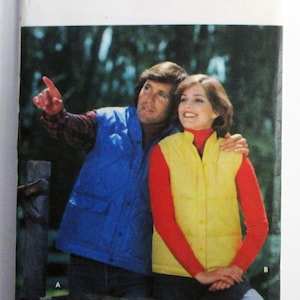May include: A vintage Butterick pattern envelope featuring a couple wearing vests. The man wears a blue vest over a plaid shirt, and the woman wears a yellow vest over a red turtleneck. The text "Butterick" is at the top.