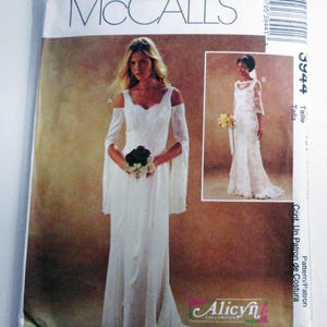 May include: A McCall's sewing pattern featuring a white wedding dress with long sleeves and a flowing skirt. The pattern includes a smaller image of a different dress style. The pattern is labeled "3944" and includes the "Alicyn Exclusives" logo.