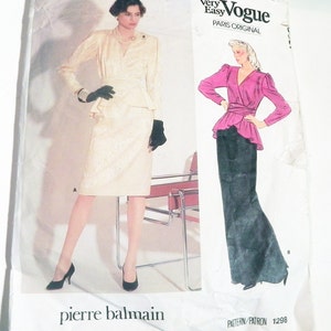 May include: A Very Easy Vogue Paris Original sewing pattern envelope, number 1298, by Pierre Balmain. The front displays two garment variations: a cream-colored wrap-style dress and a combination of a magenta long-sleeved top with a black skirt.
