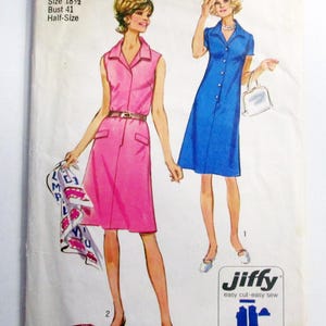 May include: Vintage Simplicity sewing pattern 9382. The pattern features illustrations of two dresses: a pink sleeveless dress with a belt and a blue button-down dress. The pattern includes the text "Jiffy easy cut easy sew".