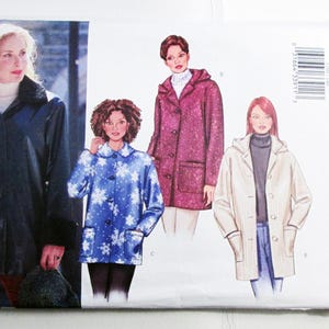 May include: Butterick sewing pattern envelope featuring illustrations of women's coats. The coats include a navy blue raincoat, a blue snowflake-patterned coat, a burgundy hooded coat, and a cream-colored hooded coat.