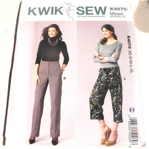 May include: Kwik Sew pattern K4070 for misses in sizes XS-S-M-L-XL. The envelope features two views: view B shows high-waisted, straight-leg trousers with a subtle checkered pattern, and view A shows cropped, wide-leg pants with a dark, abstract print.