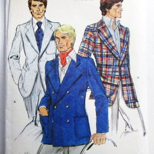May include: A Very Easy Vogue sewing pattern envelope for size 44, featuring illustrations of three blazers: a light pinstripe suit, a solid blue double-breasted blazer with gold buttons, and a multi-colored plaid blazer, all worn with collared shirts.