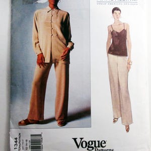 May include: A Vogue Patterns sewing pattern envelope for Anne Klein II designs, featuring a beige long-sleeve top with toggle closures and matching trousers, alongside a brown camisole with thin straps and wide-leg pants, labeled 1344, size 12-14-16.