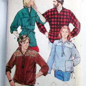 May include: A Butterick sewing pattern envelope for size 12, featuring illustrations of four shirts. Designs include a green tunic, a red and black buffalo plaid shirt, a brown shirt with a textured yoke, and a light blue shirt with a white yoke.