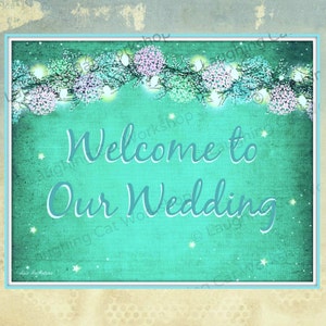 May include: A teal green wedding sign with white lights and flowers. The sign says "Welcome to Our Wedding".