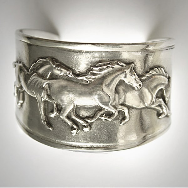 Friso de caballos mustang al galope en brazalete hecho a mano por un artista estadounidense en peltre plateado.