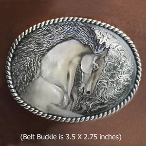 Puede incluir: Hebilla de cintur&oacute;n de plata con un dise&ntilde;o grabado detallado de la cabeza de un caballo blanco sobre un fondo floral. (La hebilla del cintur&oacute;n mide 3,5 x 2,75 pulgadas)