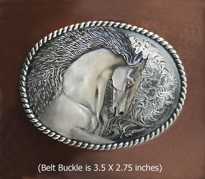 Puede incluir: Hebilla de cintur&oacute;n de plata con un dise&ntilde;o grabado detallado de la cabeza de un caballo blanco sobre un fondo floral. (La hebilla del cintur&oacute;n mide 3,5 x 2,75 pulgadas)