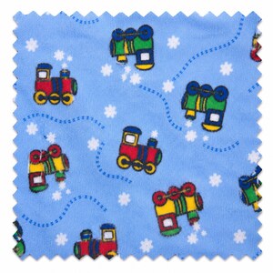 May include: A light blue fabric swatch with a repeating pattern of colorful toy trains and white star shapes. The trains are red, yellow, green, and blue. Dotted blue lines connect the trains. The fabric has a scalloped edge.