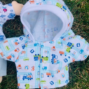 May include: A white hooded jacket with a blue and green print of cars, trucks, and traffic signs. The jacket has a white hood with a white trim.