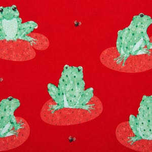 May include: A vibrant red fabric featuring a repeating pattern of light green spotted frogs sitting on red lily pads, interspersed with small black and white flies. The frogs are depicted in various poses, including facing forward and sideways.