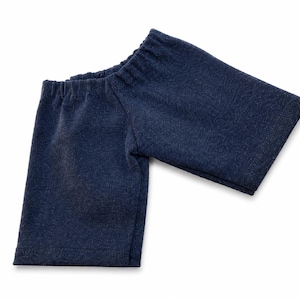May include: A dark navy blue fabric sleeve with a textured, fleece-like appearance. The garment piece features an elasticized opening at the top, designed to gather around an arm or leg, with a straight, hemmed edge at the bottom opening.