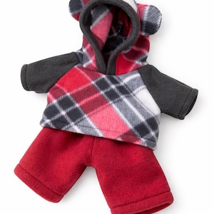 May include: A two-piece fleece outfit consisting of a hooded sweatshirt and matching shorts. The hoodie features a red, white, and black plaid pattern with solid dark grey sleeves and attached bear ears on the hood. The shorts are solid red.