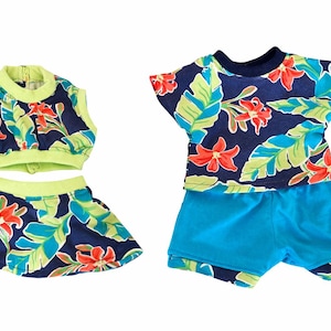 May include: Two-piece doll outfit and a matching t-shirt and shorts set. The outfits feature a navy blue floral pattern with red flowers and green leaves. The trim is a bright green, and the shorts are a solid light blue.