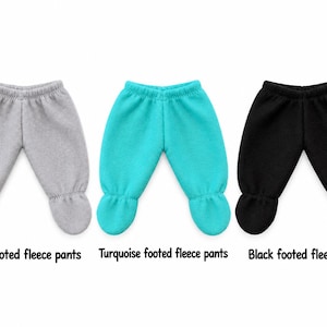 May include: Three pairs of footed fleece pants in gray, turquoise, and black. Each pair features an elasticized waistband and integrated foot coverings. The text below the items reads: Gray footed fleece pants, Turquoise footed fleece pants, Black footed fleece pants.