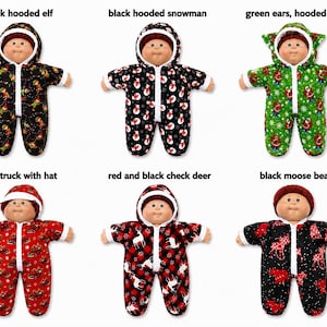 May include: Six dolls wearing different patterned hooded jumpsuits with front zippers. Patterns include black with elves, black with snowmen, green with Santa, red with trucks, red and black plaid with deer, and black with moose and bears.