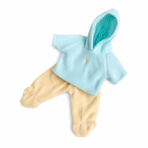 May include: A light blue short-sleeved hooded sweatshirt with a small embroidered detail on the chest, paired with pale yellow footed pants. The set is made of a soft, fleece-like fabric, featuring a hood with a bright turquoise interior lining.