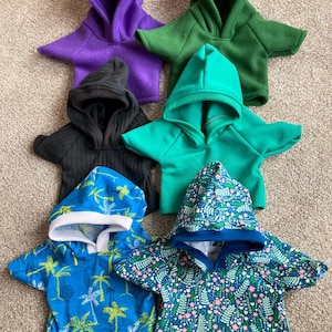 May include: A set of three ceramic mugs with a speckled, matte finish. The mugs are in shades of cream, light gray, and dark gray. Each mug has a simple, minimalist design, perfect for coffee or tea.