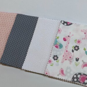 May include: Five fabric swatches, each with a different pattern. The swatches are arranged from left to right: pink with white polka dots, pink with white floral print, gray with white diamond pattern, white with a subtle texture, and white with a pink giraffe, pink birds, and pink flowers.