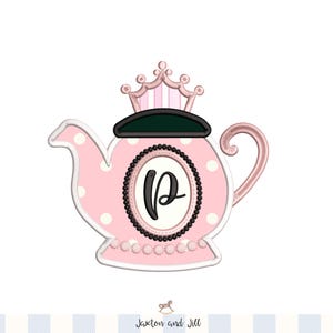 Puede incluir: Ilustración de una tetera rosa con lunares y una corona encima. La tetera tiene un marco ovalado con cuentas en blanco y negro con la letra "P" en su interior. La tetera tiene un asa y un pico rosas. La ilustración está sobre un fondo blanco.