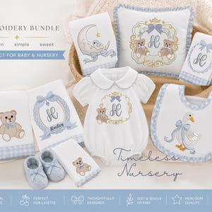 May include: A baby embroidery bundle featuring a white romper with a teddy bear, a bib with a goose, a square pillow with two teddy bears, and several towels with moon, bear, and monogram designs. The items feature blue gingham trim and embroidery.