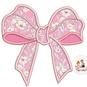 May include: A pink bow with a white floral pattern. The bow has a pink outline and is a digital embroidery design.