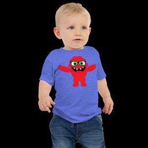 May include: A toddler wearing a blue heather t-shirt with a red monster graphic wearing green glasses. The monster is smiling and has its arms outstretched.