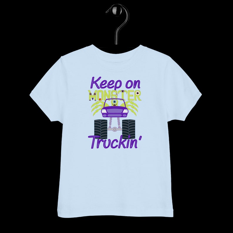 May include: Light blue toddler t-shirt with a purple monster truck graphic and the text "Keep on Monster Truckin'" in purple.