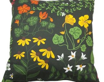 May include: A green pillow with a floral pattern featuring yellow, orange, white, and brown flowers. The flowers are on a dark green background.