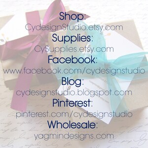 May include: A close-up of a wrapped gift box with a blue and purple ribbon. The box has text on it that reads "Shop: CydesignStudio.etsy.com Supplies: CySupplies.etsy.com Facebook: www.facebook.com/cydesignstudio Blog: cydesignstudio.blogspot.com Pinterest: pinterest.com/cydesignstudio Wholesale: yagmindesigns.com"