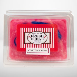 May include: A square container of pink and blue cotton candy fudge. The label reads "Big Bear Chocolates Fresh Fudge (509) 991-2662 bigbearchocolates.com Spokane, WA" and "Cotton Candy".