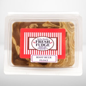 May include: A square container of brown and tan swirl fudge with a red label that reads "Big Bear Chocolates Fresh Fudge (509) 891-2662 bigbearchocolates.com Spokane, WA" and "Root Beer Float".