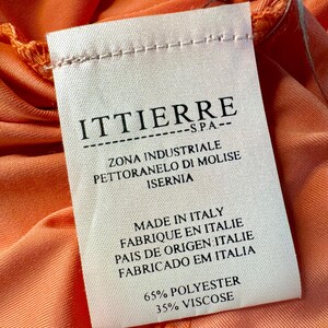 Może przedstawiać: Biała metka odzieżowa z czarnym tekstem, kt&oacute;ry brzmi "ITTIERRE S.P.A. ZONA INDUSTRIALE PETTORANELO DI MOLISE ISERNIA MADE IN ITALY FABRIQUE EN ITALIE PAIS DE ORIGEN ITALIE FABRICADO EM ITALIA 65% POLYESTER 35% VISCOSE".