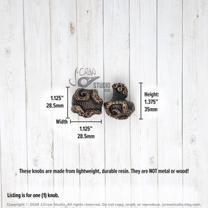 May include: Two dark brown resin cabinet knobs featuring a textured octopus tentacle design. The knobs measure 1.125 inches in width and 1.375 inches in height. The text J.Crow Studio 2026 is visible, along with notes stating they are made of resin.