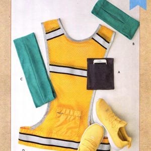 May include: A Kwik Sew K4360 sewing pattern envelope featuring a yellow mesh vest with reflective silver stripes, a black pocket with a white smartphone, two teal fabric bands, and a pair of yellow athletic sneakers. Text reads: Kwik Sew K4360.