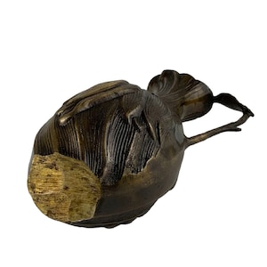 Pu&ograve; includere: Una scultura in bronzo di un uccello con una superficie dettagliata e testurizzata. L'uccello ha un collo lungo e curvo e una piccola testa. La scultura &egrave; in stile vintage.