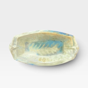 May include: An oval ceramic dish featuring a crystalline glaze with a blend of cream, pale yellow, and soft blue hues. The surface displays intricate, flower-like crystal formations scattered across the interior, with a smooth, glossy finish.