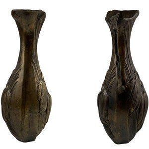 Pu&ograve; includere: Un paio di piedi decorativi per vaso in bronzo antico con un motivo floreale. I piedi sono finemente intagliati e hanno una patina marrone scuro.