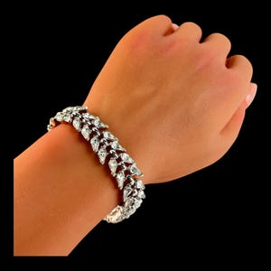 Pulsera vintage de eslabones plateados con doble hilera de brillantes diamantes de imitación y corona Trifari, años 50 y 60. Fabricada en Estados Unidos.