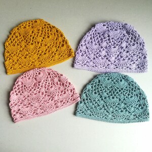 May include: Four crocheted hats in different colors: mustard yellow, lavender, pink, and teal.