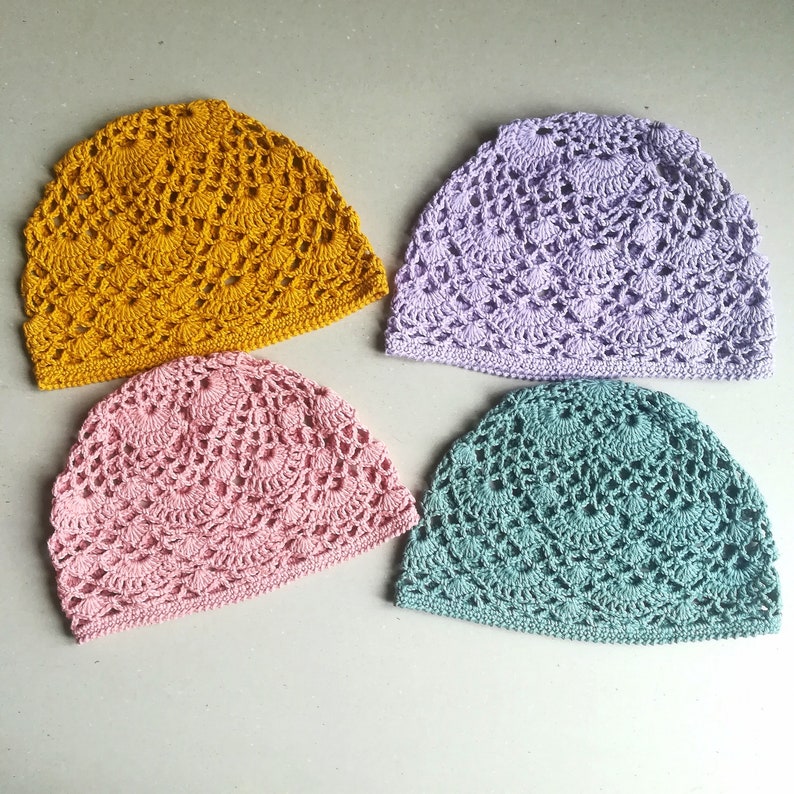 May include: Four crocheted hats in different colors: mustard yellow, lavender, pink, and teal.