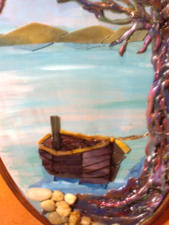 Serene ocean scene depicting a boat tied to a tree on a rocky island. Handmade mixed media artwork with tree and boat. Artisan-crafted scene