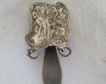 May include: Silver bookmark with a detailed floral design and a pointed tip. The bookmark has two small loops on the top.