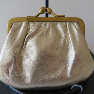 May include: A gold-colored leather coin purse with a brass clasp.