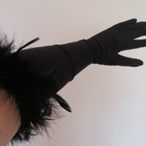 May include: Black long gloves with a feather trim at the wrist.